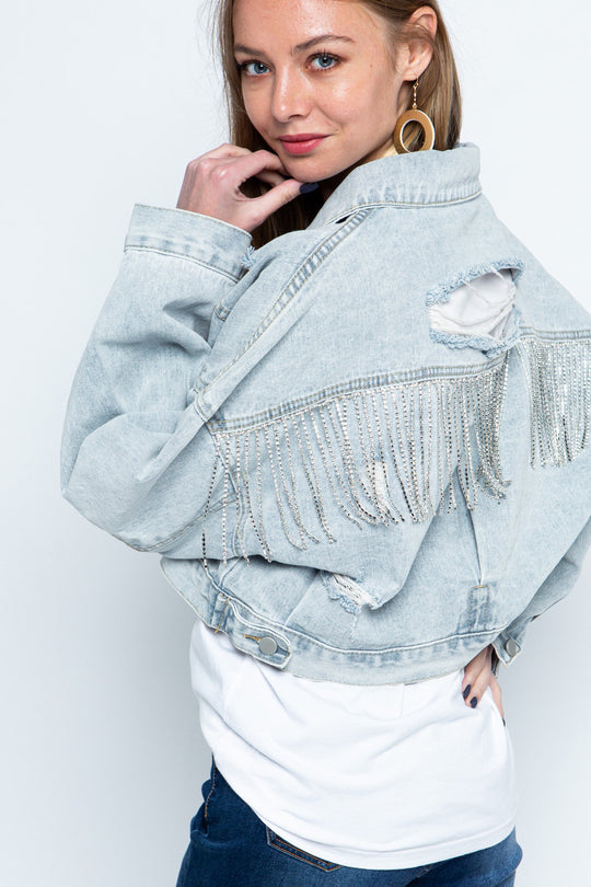 Stylish denim jacket for women with ripped details, rhinestone embellishments, tassel accents, and long sleeves.